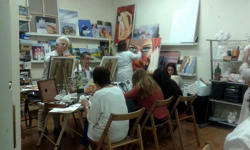 Alumnos en clase de pintura trabajando en sus cuadros