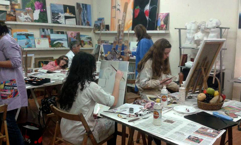 Alumnos en clase de pintura trabajando en sus cuadros