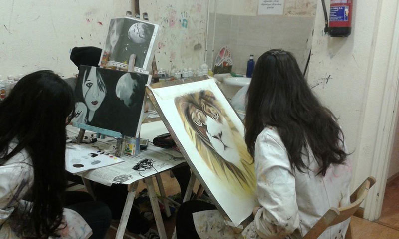 Alumnos en clase de pintura trabajando en sus cuadros