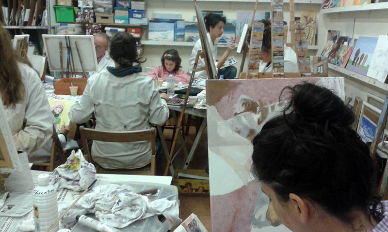Alumnos en clase de pintura trabajando en sus cuadros