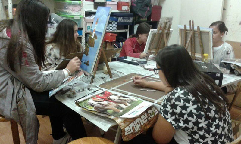 Alumnos en clase de pintura trabajando en sus cuadros